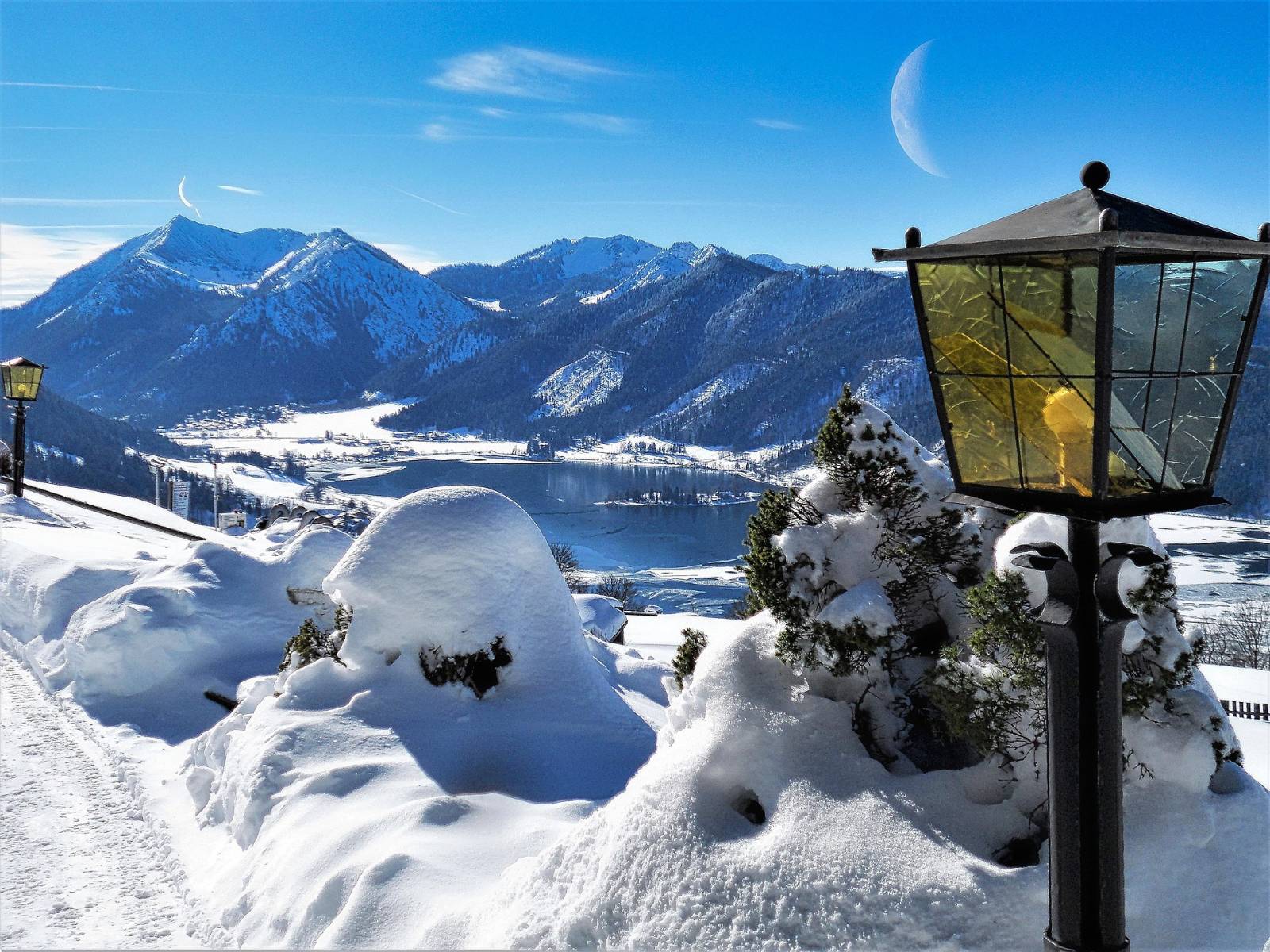 Der Schliersee im Winter, Sonne über der verschneiten Bergkette