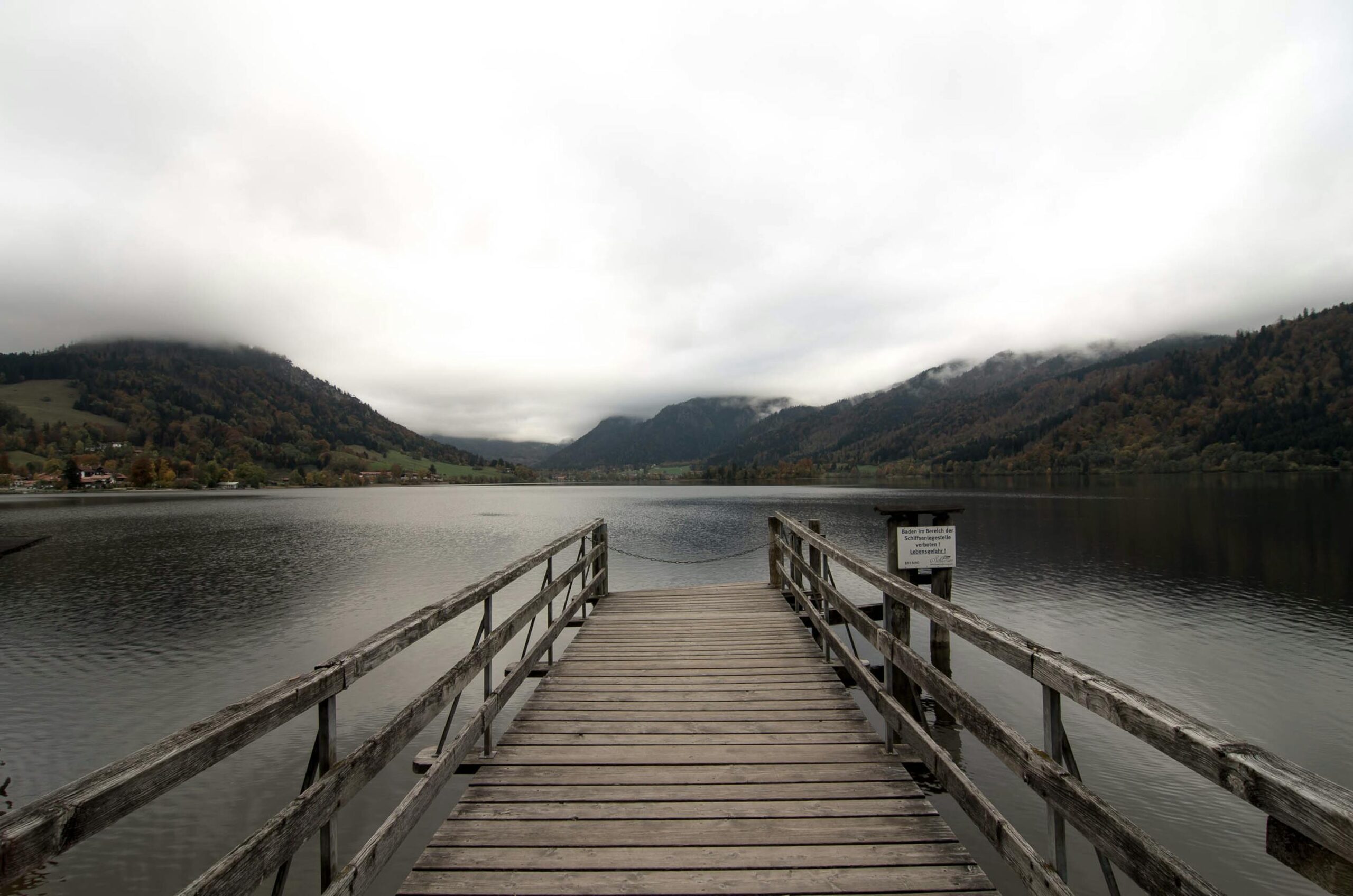 Holzsteg am Schliersee mit nebligen Bergen — Atmosphäre für spontane Last-Minute-Aufenthalte